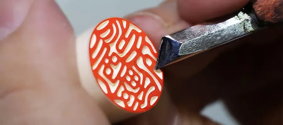 熟練の職人が手作業で実印を彫刻している画像